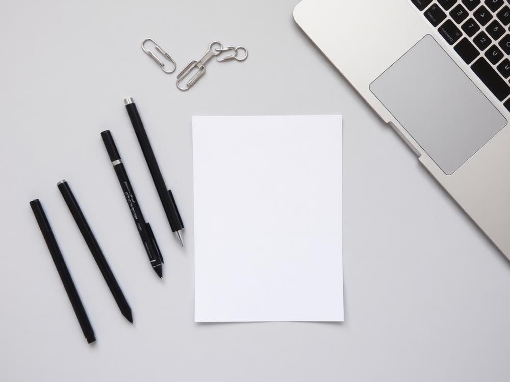 Pens arranged on a tidy office desk with notepad